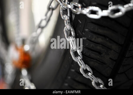 Horizontal detail shot of some new snow chains on a car's tire. Stock Photo