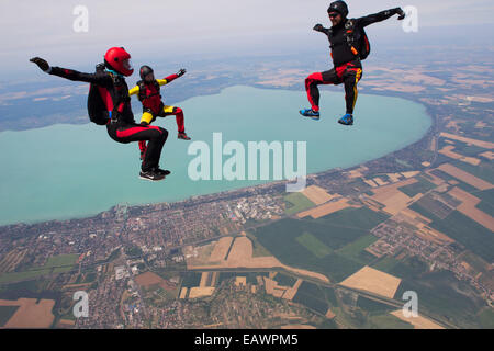 Freefly skydivers are over a spectacular land and fields scenery in the sky with 130 MPH. Stock Photo