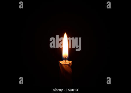 Silver candle burning on a black background Stock Photo