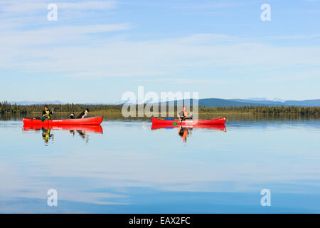 Two people canoe on a quiet lake Stock Photo