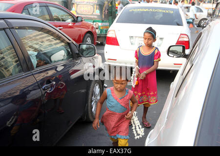 Dhaka 21 November 2014. two child on the side of the road attempts to sell flowers to passing commuters in cars and buses. Stock Photo