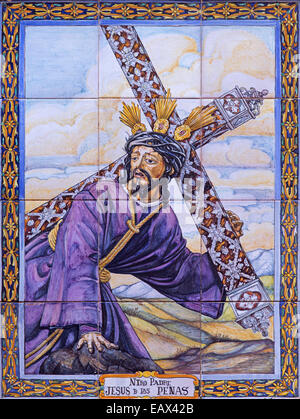 Seville - ceramic tiled Christ with the cross by Juan Aragon from 20. cent. on the facade of church Iglesia de San Esteban. Stock Photo