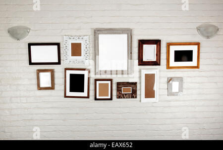 empty frames and lamps on white bagged wall Stock Photo