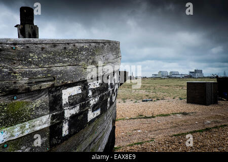 A wooden fishing boat abandoned on the beach at Dungeness in Kent.  A site of special scientific significance. Stock Photo