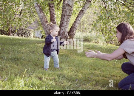 Baby girl taking her first steps outdoors Stock Photo