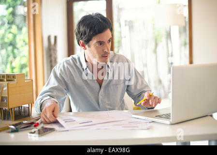 Businessman working at home on laptop computer Stock Photo