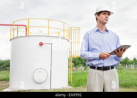 Engineer using digital tablet at industrial chemical storage site Stock Photo