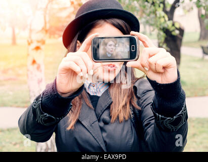 Beautiful young brunette hipster stylish woman selfie in the park,selective focus Stock Photo