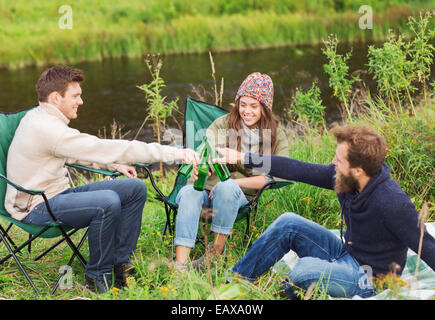 group of smiling tourists drinking beer in camping Stock Photo