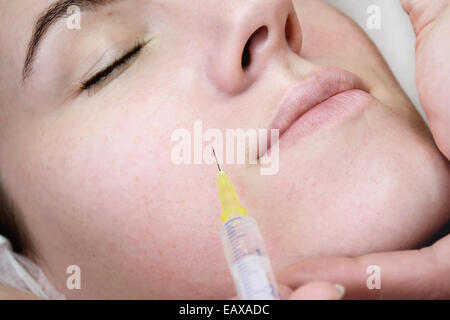 Beautiful woman gets an injection in her face in spa salon Stock Photo