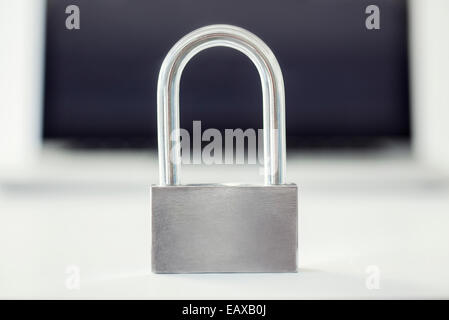 Close-up of padlock with laptop computer in background Stock Photo