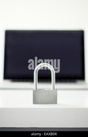 Padlock in front of laptop computer representing internet security Stock Photo
