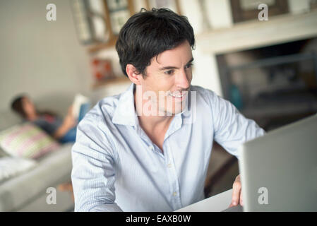 Man using laptop computer in living room Stock Photo