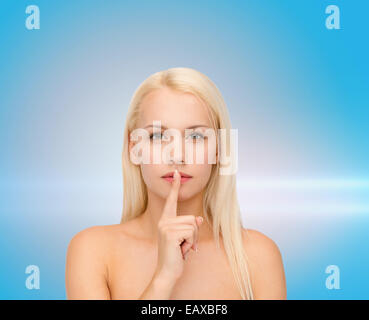 calm young woman with finger on lips Stock Photo