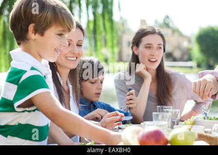 Family eating together outdoors Stock Photo