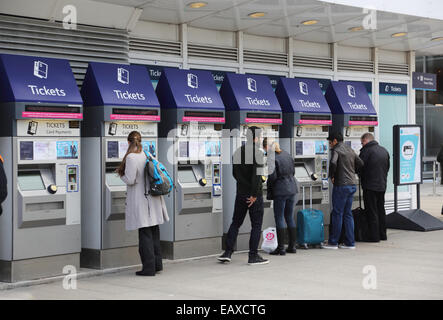 Passengers using automatic ticket machines to purchase train tickets outside London's London Bridge railway station Stock Photo