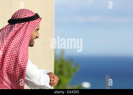 Happy relaxed arab saudi man looking the sea from a balcony of an hotel Stock Photo