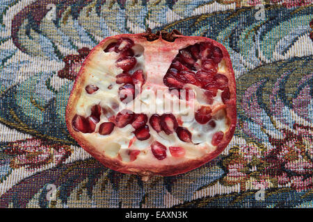 halved organic pomegranate on dining table Stock Photo