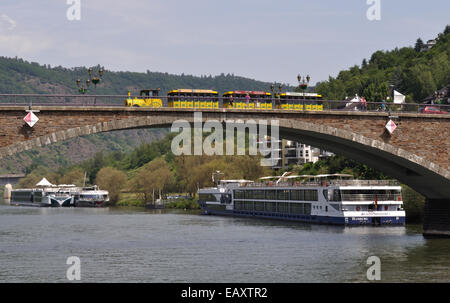 A tourist Noddy train crosses the main bridge over the Moselle towards the centre of Cochem, Germany. Stock Photo