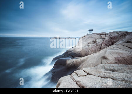 Cabin on cliff near sea with dramatic sky Stock Photo