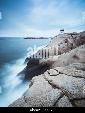 Cabin on cliff near sea with dramatic sky Stock Photo
