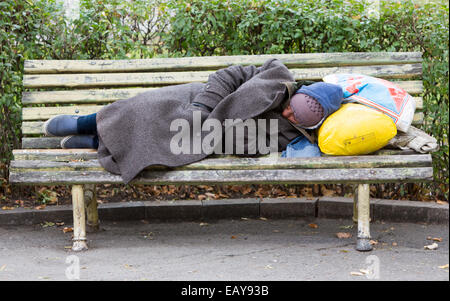 Sofia, Bulgaria - November 4, 2014: Homeless man is sleeping on a bench in the center of Sofia. Years after joining the EU Bulga Stock Photo