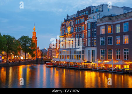 Night city view of Amsterdam canal, bridge and Munttoren tower, Holland, Netherlands. Stock Photo