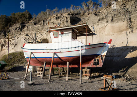 A fishing boat undergoing maintenance in Vlichada, Santorini, Greece. Stock Photo