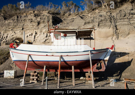 A fishing boat undergoing maintenance in Vlichada, Santorini, Greece. Stock Photo