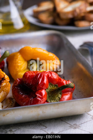 Fresh roasted red and yellow peppers on metal tray, selective focus Stock Photo