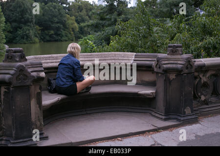 A woman sitting in one of the balcony's on Balcony Bridge in Central Park, New York City. Stock Photo