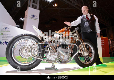 Motorcycle Live, The NEC, Birmingham, England, UK. 22nd November 2014. Today is the feast day of St Columbanus (23rd November).  St Columbanus is the patron saint of motorcyclists and the Reverend Paul Sinclair was on hand this weekend at the Motorcycle Live show in Birmingham to bless the gathered bikes and bikers. He is pictured giving a blessing to Vic and Lin Jefford and their unique hand built bike. Credit:  Simon Hadley /Alamy Live News Stock Photo