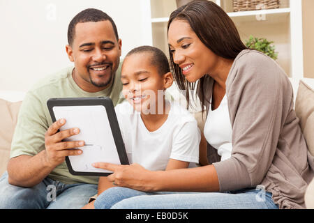 African American family, parents and son, having fun using tablet computer together at home Stock Photo