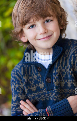 Young happy smiling boy outside arms folded Stock Photo