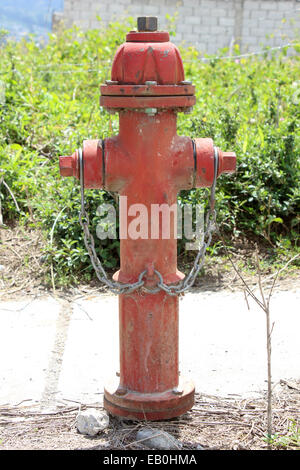 A red fire hydrant next to a road in Cotacachi, Ecuador Stock Photo