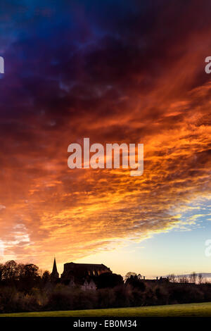 Malmesbury, Wiltshire, UK. 23rd November 2014. The sky turns orange as the sun sets over the Abbey in the Wiltshire hillside town of Malmesbury. Credit:  Terry Mathews/Alamy Live News Stock Photo