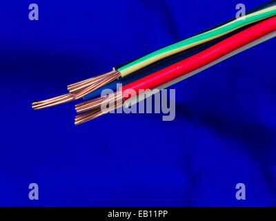 High voltage three phase electrical cable with copper conductors - close up on blue background Stock Photo