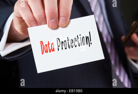 A businessman holding a business card with the words, Data Protection, written on it. Stock Photo