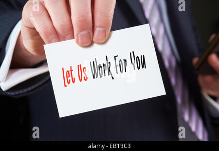 A businessman holding a business card with the words, Let Us Work For You, written on it. Stock Photo