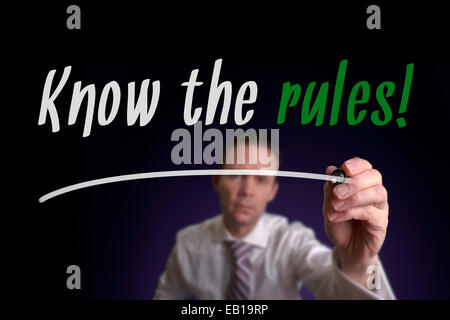 A businessman writing Know The Rules on a screen. Business Concept. Stock Photo