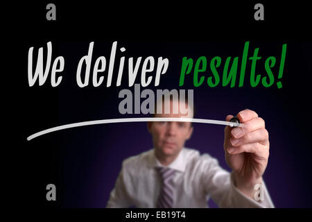 A businessman writing We Deliver Results on a screen. Business Concept. Stock Photo
