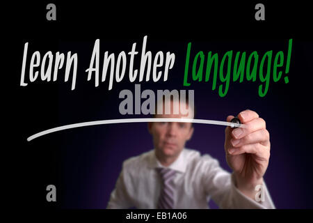 A businessman writing Learn Another Language on a screen. Business Concept. Stock Photo
