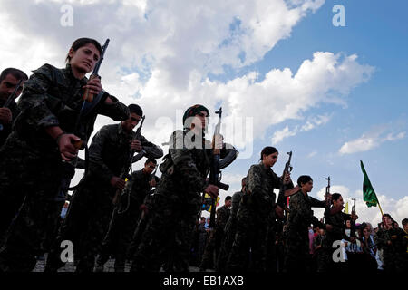 Kurdish fighters of the People's Protection Units YPG and the Women's Protection Units YPJ taking part in a funeral ceremony for Kurdish fighters killed by Islamic State ISIS or ISILmilitants in a cemetery near the city of Al-Malikiyah also called Derek ( Kurdish ) in Al Hasakah or Hassakeh district in northern Syria Stock Photo