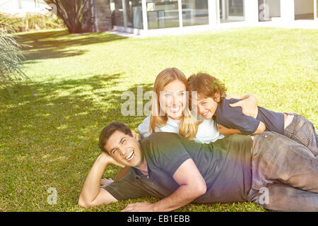 Happy family with a child laying in the garden in front of a house Stock Photo