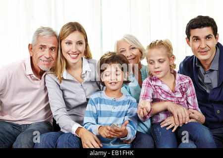 Family watching Smart TV with remote control in living room Stock Photo