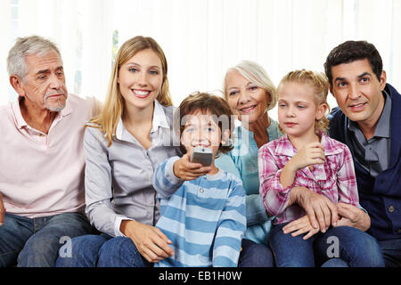 Big happy family watching Smart TV with remote control in living room Stock Photo