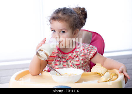 Pretty kid drinking milk from glass Stock Photo