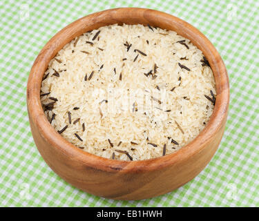 white and wild rice in wooden  bowl on kitchen table Stock Photo