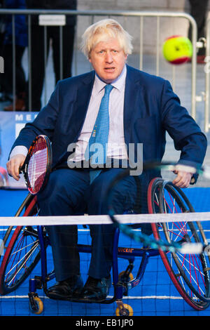 City Hall, London, UK. 24th November, 2014. Mayor Boris Johnsonwelcomes the world's best wheelchair tennis players with a game of mini tennis outside City Hall. The players are in London to compete in the NEC Wheelchair Tennis Masters 2014, being held at the Lee Valley Hockey and Tennis Centre, being held from 26 - 30 November. PICTURED: Mayor Boris Johnson keeps his eye on the ball. Credit:  Paul Davey/Alamy Live News Stock Photo