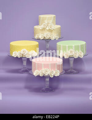 white rose icing on four different colors of wedding cakes Stock Photo